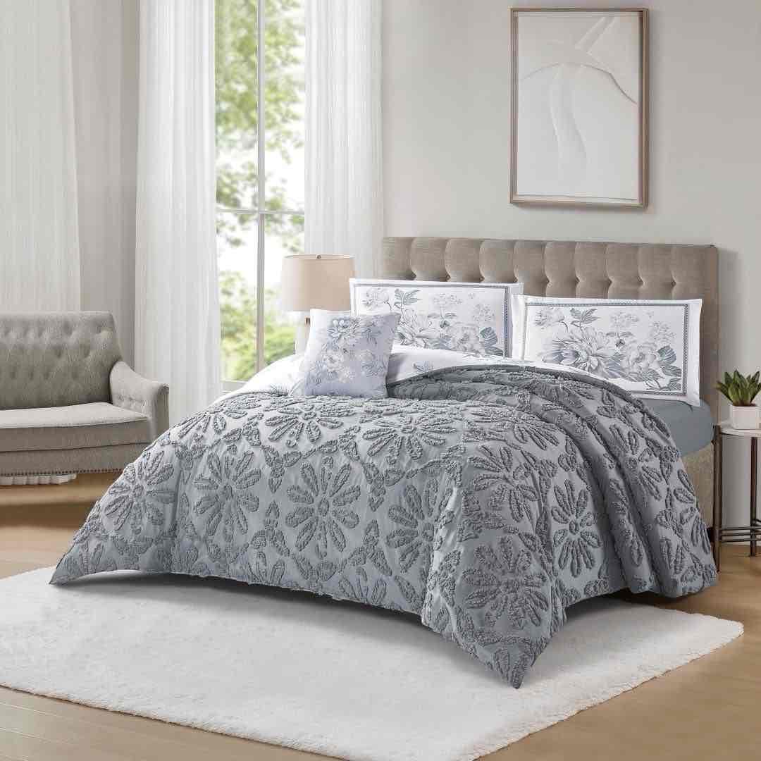 Colcha gris con relieve floral en una recámara